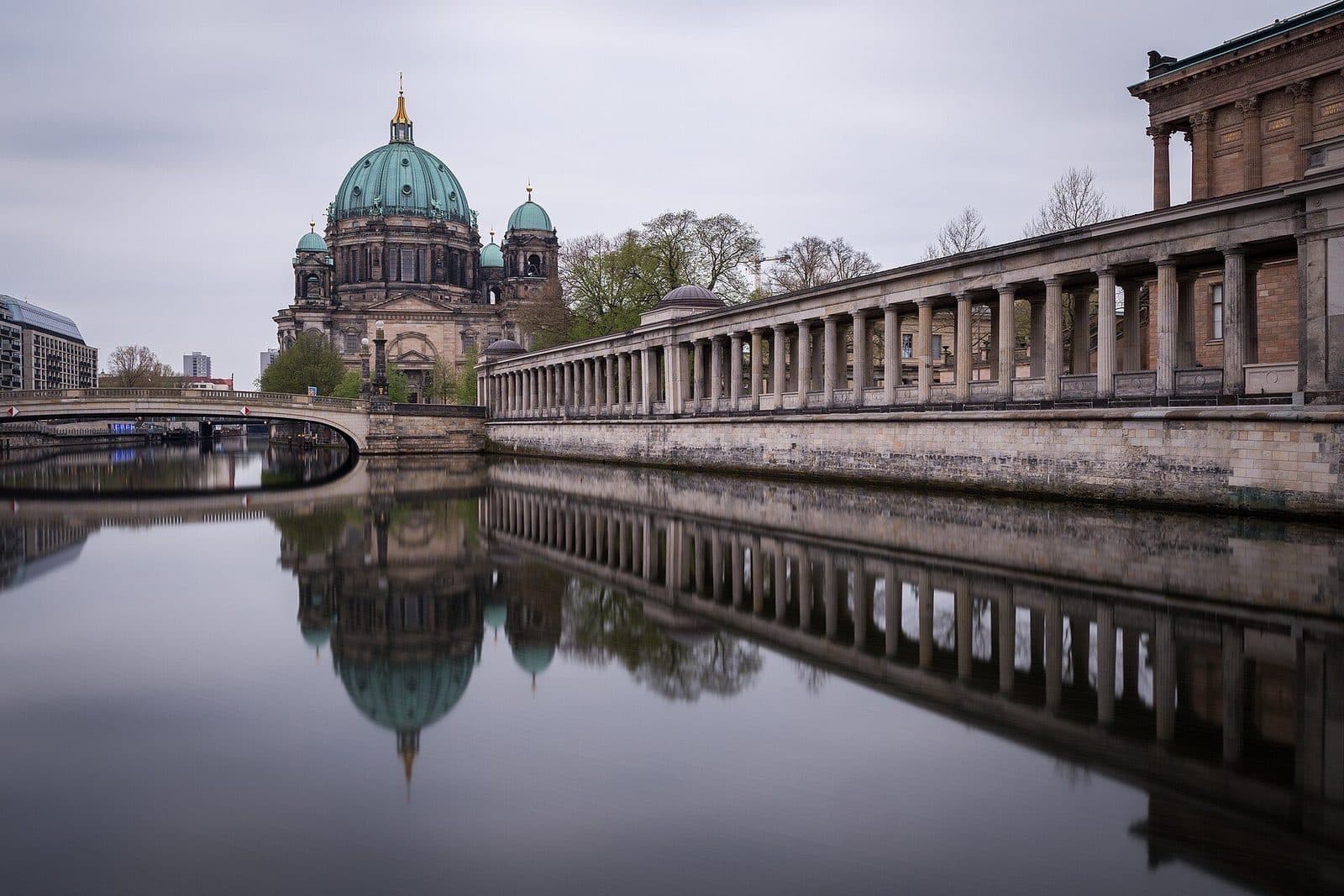 De groene koepels van de Berliner Dom en de zuilengalerij van de Museumsinsel weerspiegeld in het stille water van de Spree