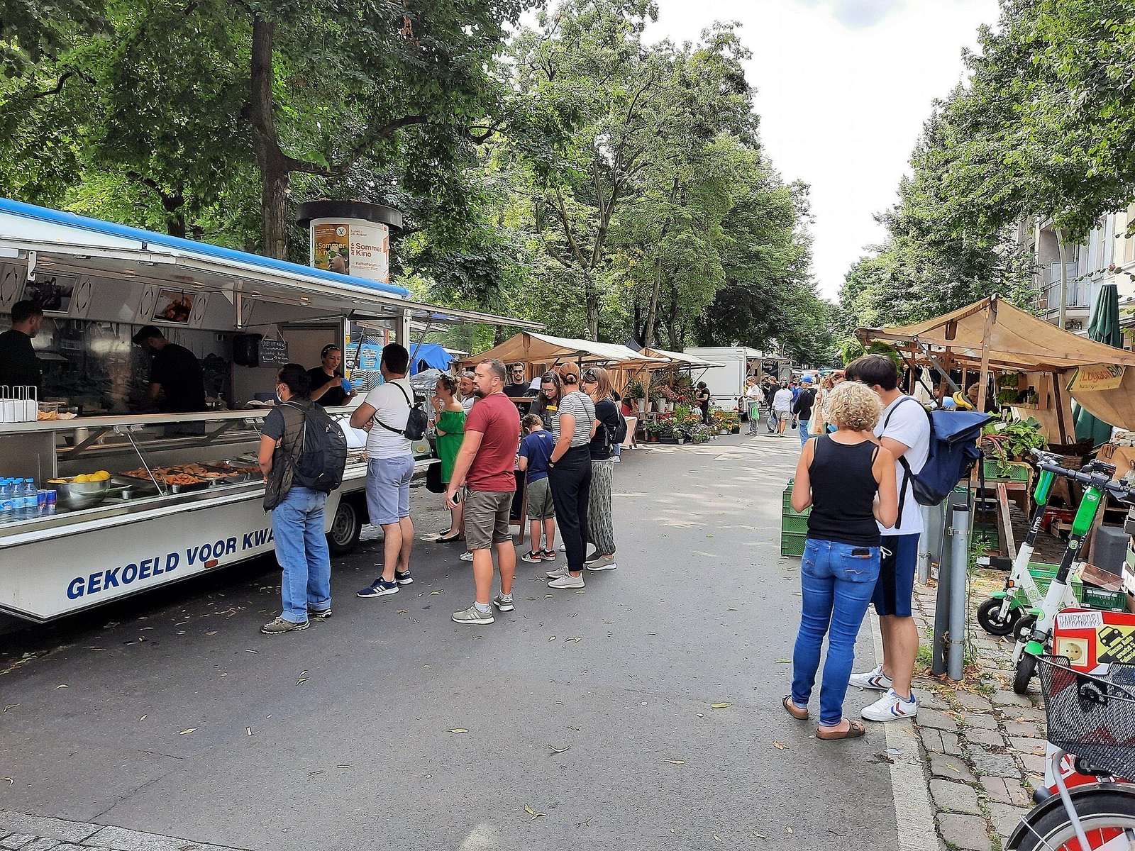 Bezoekers bij de kramen van de weekmarkt op de Boxhagener Platz in Friedrichshain