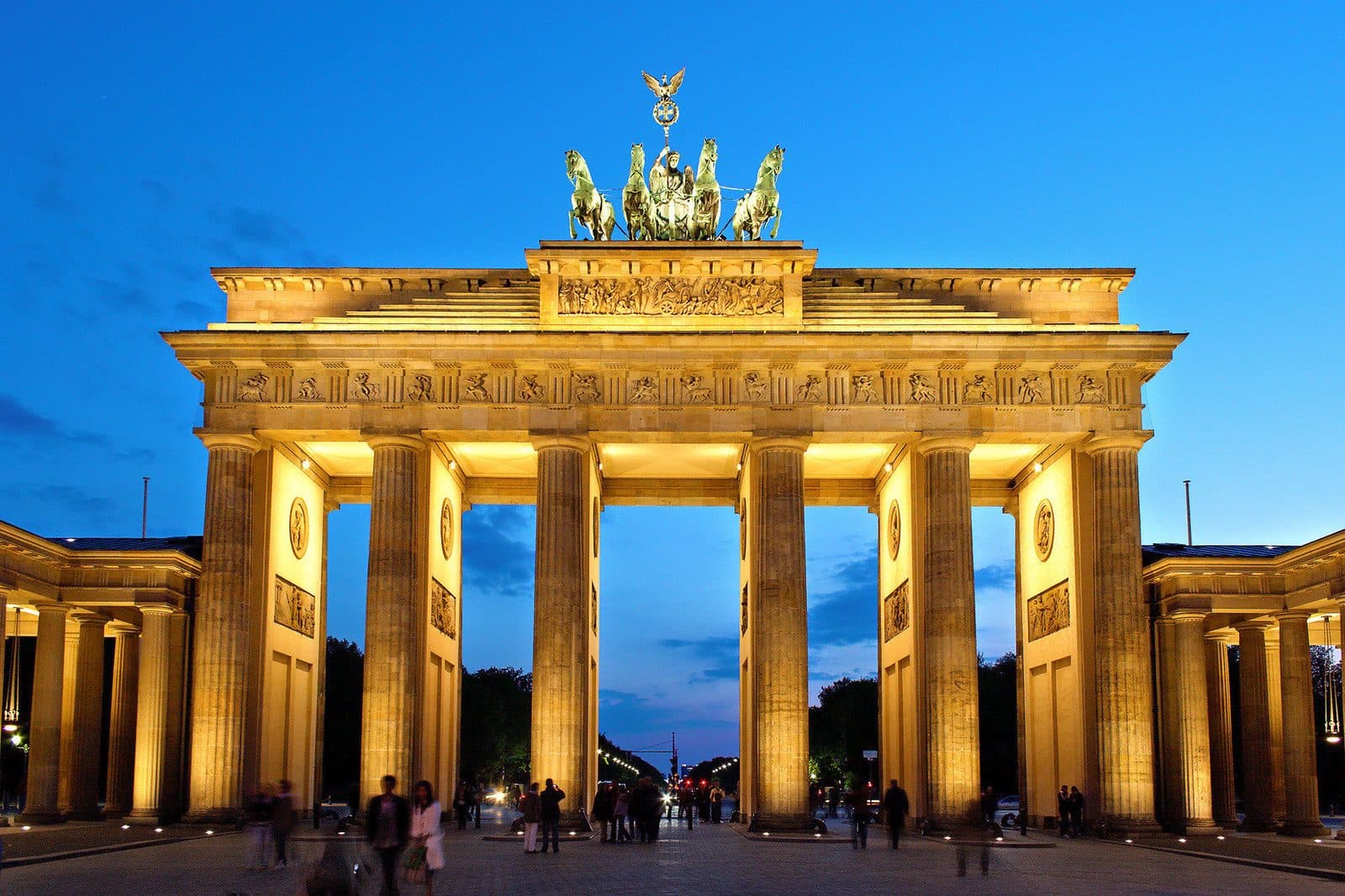 De verlichte Brandenburger Tor met de quadriga bovenop, tegen een diepblauwe avondlucht