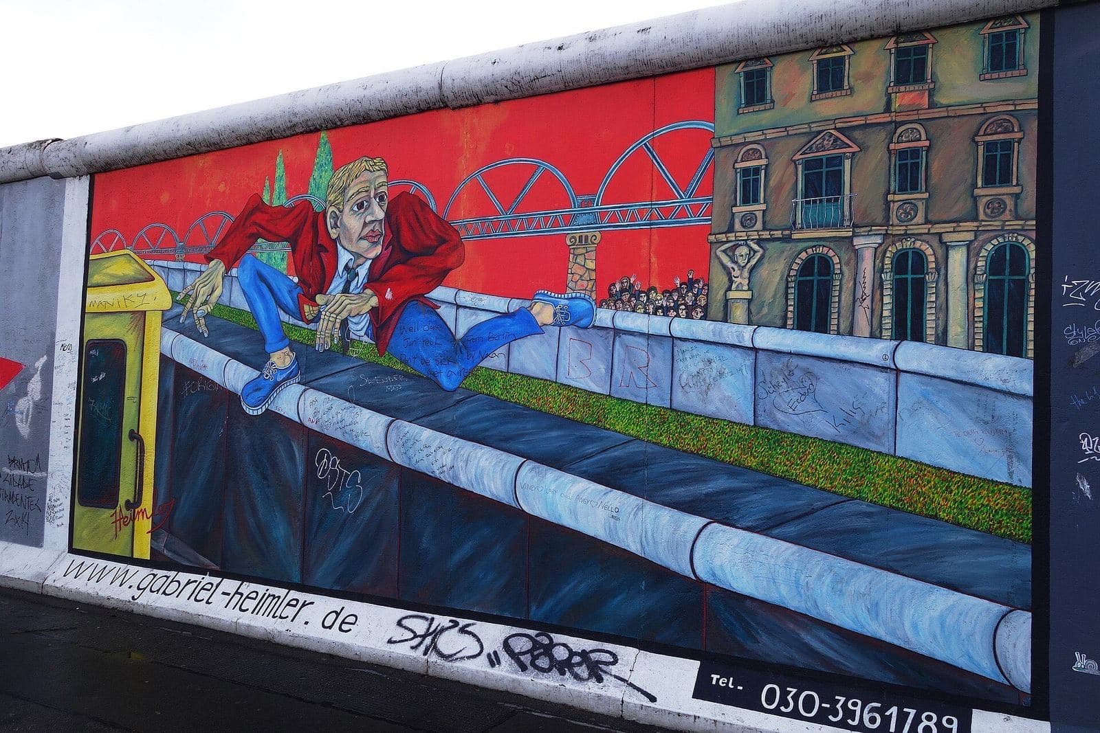 Een kleurrijke muurschildering van een man die over de Muur springt, op de East Side Gallery aan de Mühlenstraße