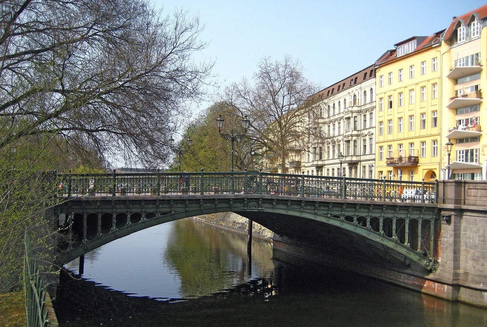 De Admiralbrücke over de Landwehrkanal in Kreuzberg, met gele en witte negentiende-eeuwse gevels en bomen langs het water