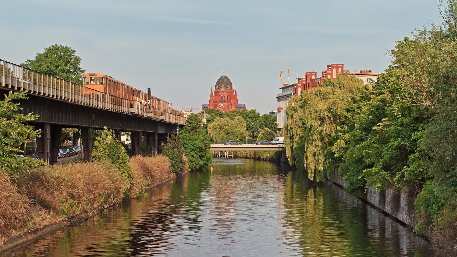 De groene oevers van de Landwehrkanal in Kreuzberg met de bovengrondse U-Bahn langs het water