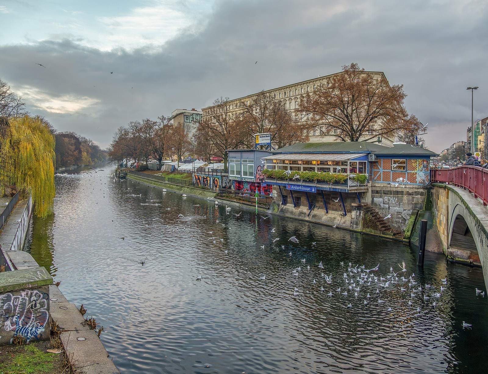 De Landwehrkanal bij het Maybachufer in Neukölln, met een boothuis en herfstbomen langs het water