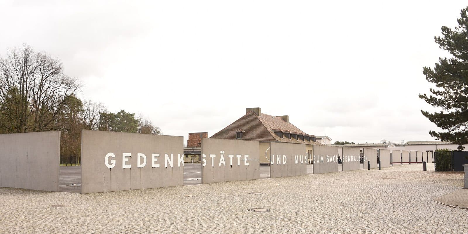 De ingang van de Gedenkstätte und Museum Sachsenhausen in Oranienburg, met de naam op een lange betonnen muur