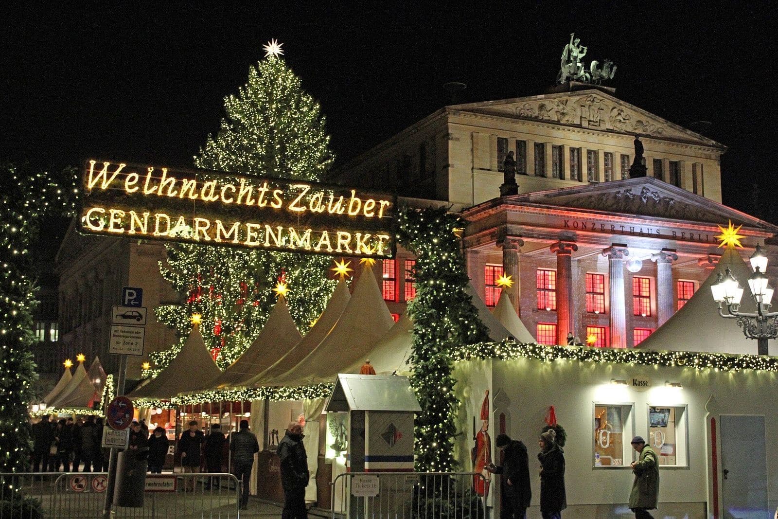 De verlichte kerstmarkt op de Gendarmenmarkt met een grote kerstboom voor het Konzerthaus